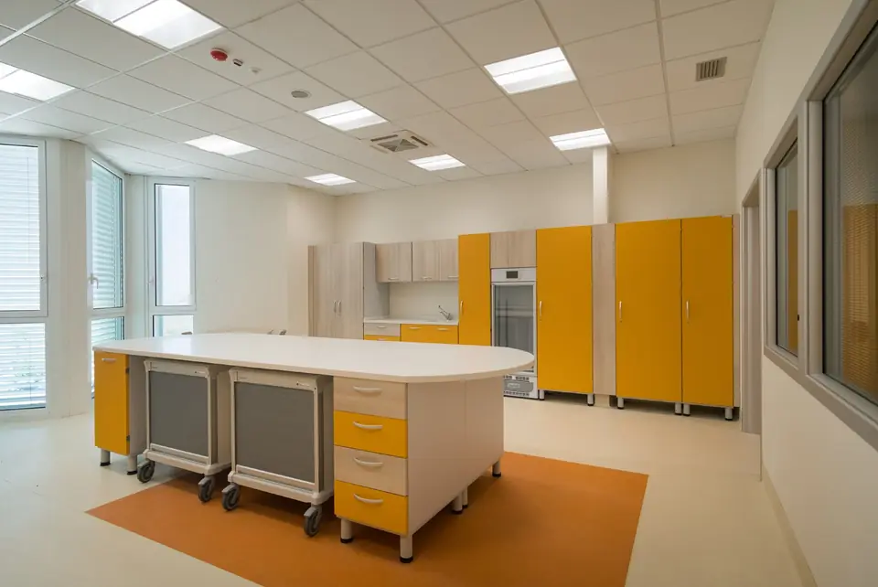 Clinical workstation with yellow modular cabinets and mobile pedestals
